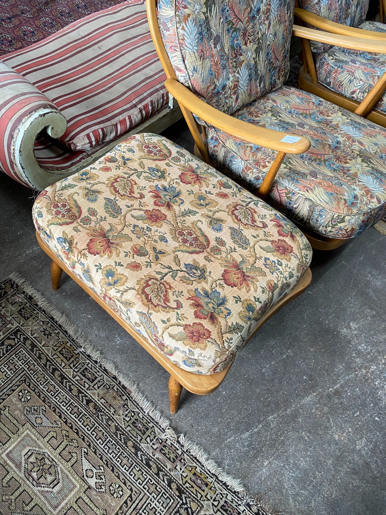 An Ercol beech three piece lounge suite and footstool, settee length 174cm, width 80cm, height 82cm